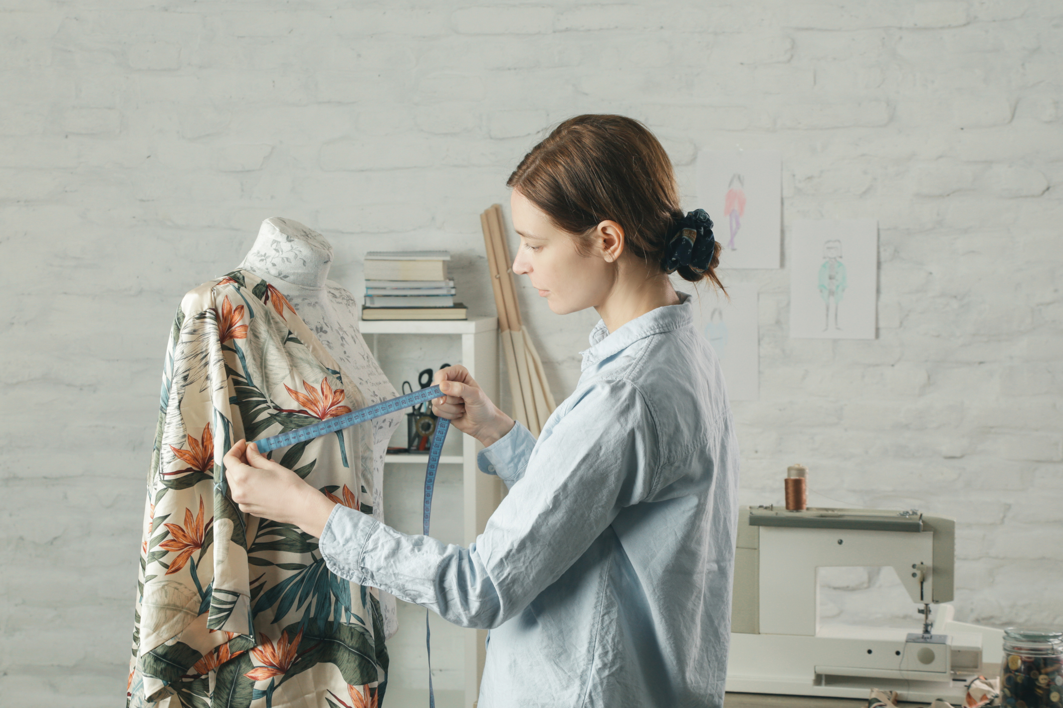 Tailor adjusts garment design on mannequin in workshop - fashion atelier, slow fashion, tailor craft, handmade clothes